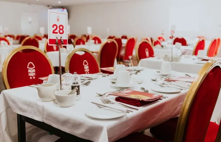 Ảnh chụp bên trong một khu vực tiếp đón khách VIP tại The City Ground, với bàn ăn và view ra sân.