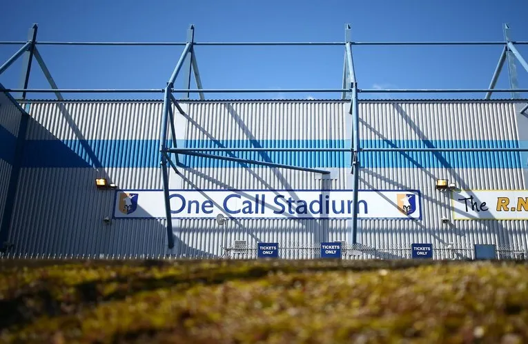 Biển hiệu lối vào sân vận động Field Mill, thể hiện tên gọi và logo CLB Mansfield Town