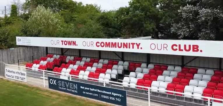 Khu vực khán đài có mái che tại sân St James Park của Brackley Town, nơi người hâm mộ tránh mưa nắng cổ vũ đội nhà.