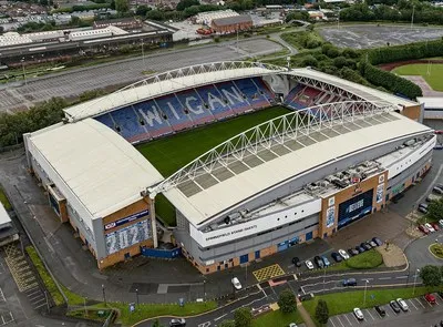 Toàn cảnh sân vận động Brick Community nhìn từ trên cao, biểu tượng của Wigan Athletic và Wigan Warriors